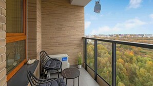 Ein Balkon mit Blick auf eine bewaldete Landschaft, einer Heizung und einem hängenden Ornament.
