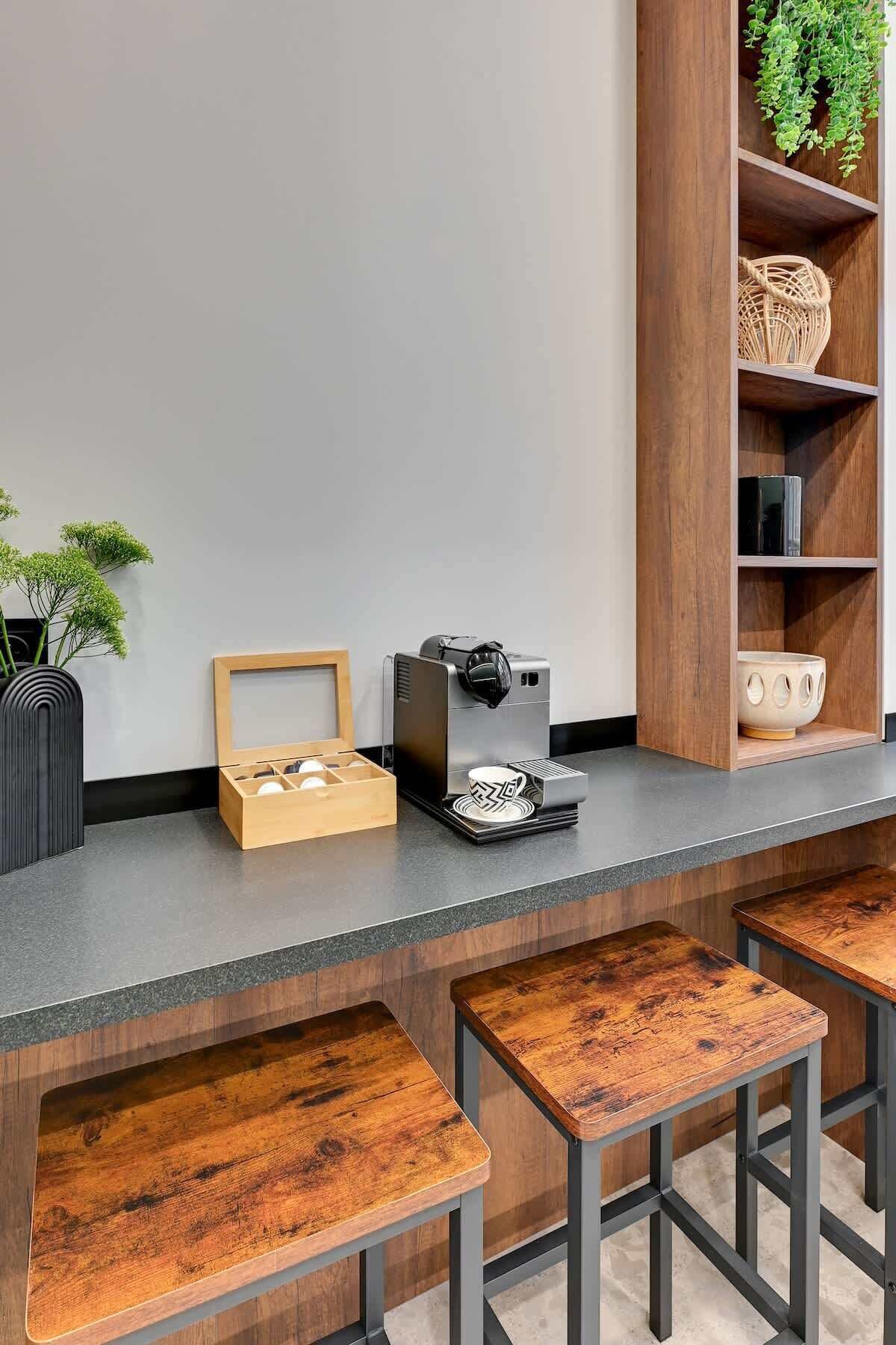 A kitchen counter with a coffee machine, a wooden box, and a plant.