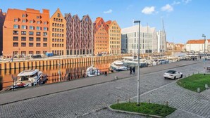 Rantavyöhyke, jossa on rakennuksia, veneitä ja mukulakivikatu.