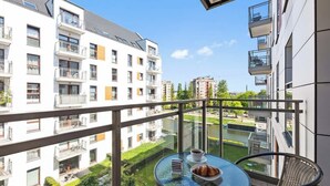 Ein Balkon mit Tisch, Stuhl, einem Croissant und einer Kaffeetasse.