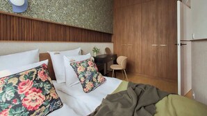Hotellihuone, jossa on sänky, työpöytä ja vaatekaappi.
