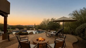 An outdoor patio with a fire pit, lounge chairs, and a pool. - Infinity Pool, Mountain Views and Putting Green (Scottsdale)