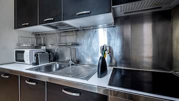 Una cocina moderna con electrodomésticos de acero inoxidable, un microondas y un lavabo.