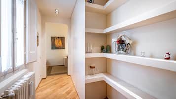 Un interior moderno con paredes blancas, suelo de madera y estanterías empotradas.