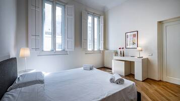 Una habitación de hotel con una cama, un escritorio y un radiador.