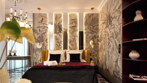 A hotel room with a bed, a side table, a decorative wall, and a bookshelf. - Hi Stay Red Velvet & Gold | Unique View (Gdańsk)