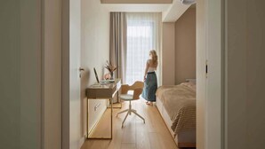 Un dormitorio con una cama, un escritorio y una silla.