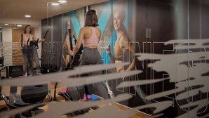 Ein Fitnessstudio mit Trainingsgeräten und einer großen Spiegelwand.