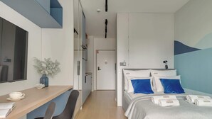 A hotel room with a desk, two beds, a TV, and a door leading to another room. - Żurawie A31 | Shipyard | Foodhall Montownia (Gdańsk)