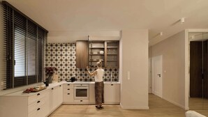 Una cucina moderna con forno a incasso, un bicchiere da vino e una ciotola di frutta sul piano di lavoro.