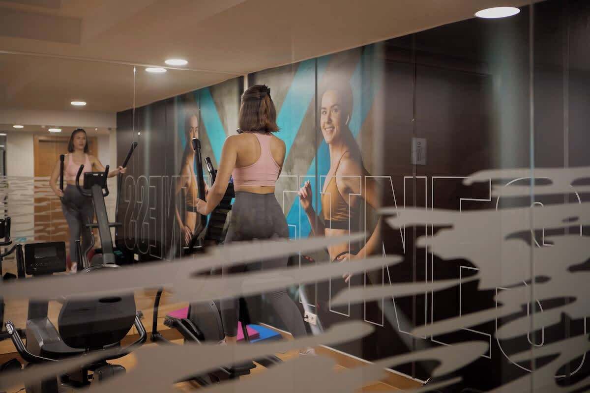 Ein Fitnessstudio mit Trainingsgeräten und einer großen Spiegelwand.