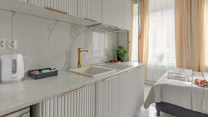 A modern kitchen with a sink, kettle, and countertop storage. - Sukiennicza | Two Independent Spaces (Gdańsk)