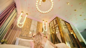 Ein Zimmer mit einem Bett, einer Chandelier und einem großen Spiegel.