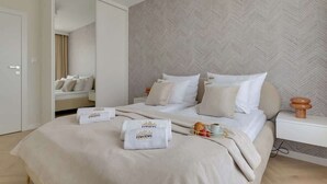 Ein Hotelzimmer mit einem großen Bett, einem Nachttisch, einem Spiegel und einem Kleiderschrank.