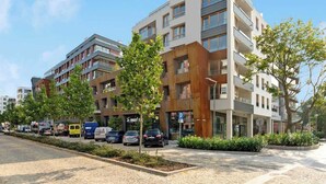 Ein mehrstöckiges Wohngebäude mit Balkonen, einem Parkschild und blauem Himmel.
