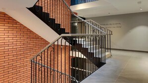 Ein modernes Interieur mit Backsteinwand, Metallgeländer und einer Treppe.