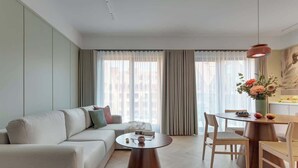 A modern living room with a sofa, a coffee table, a dining table with chairs, and a pendant light. - Granaria B503 | 2 Balconies (Gdańsk)