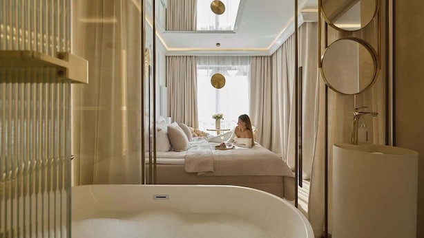A modern bathroom with a freestanding bathtub, a large mirror, and a window with curtains. - Jacuzzi Mirror Suite Granaria | AC | with Balcony (Gdańsk)