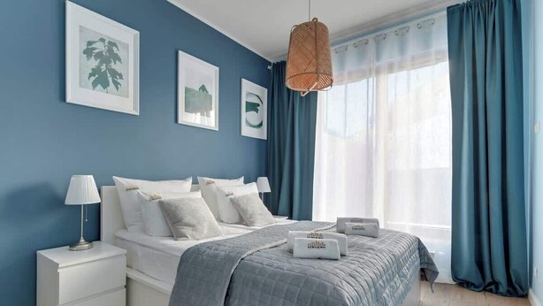 Ein Schlafzimmer mit Bett, Nachttischen, einer Lampe und Bildern an der Wand.