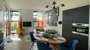 Un comedor moderno con una mesa redonda para cuatro personas, un sofá y un televisor.