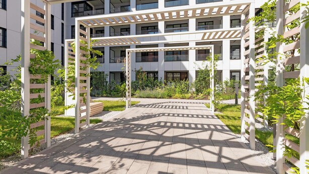 En bygning med flere etager og et overdækket udendørs område med et pergola-tag.