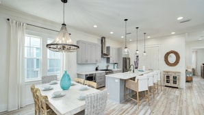 A spacious kitchen with white cabinetry, a central island, and pendant lighting. - Crisp Ocean Breeze | Private Pool | Walk to Beach | Golf Cart(LSV) (Santa Rosa Beach)