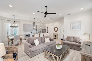 A modern living room with a sofa, coffee table, and dining area. - Crisp Ocean Breeze | Private Pool | Walk to Beach | Golf Cart(LSV) (Santa Rosa Beach)