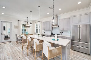 A modern kitchen with a large island, stainless steel appliances, and pendant lighting. - Crisp Ocean Breeze | Private Pool | Walk to Beach | Golf Cart(LSV) (Santa Rosa Beach)