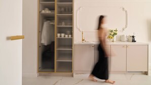 A room with a wardrobe, a mirror, a sink, and a vase with flowers. - Portovo 193 | Jacuzzi Suite | Perfect for Couples (Gdańsk)
