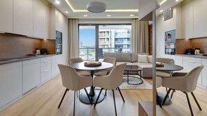 Un appartement moderne comprenant un coin repas, une cuisine et un balcon avec vue sur la ville.