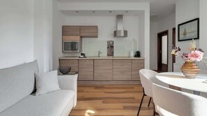 Eine moderne Küche mit Holzausstattung, einer Mikrowelle und einem Einbauofen.