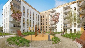 Un moderno complesso residenziale con area salotto all'aperto e un'area giochi.