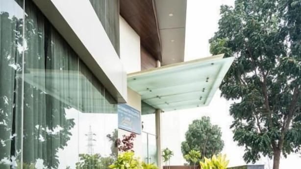 Una escalera conduce a la entrada de un edificio, con macetas a cada lado.