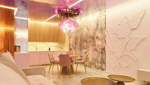 A modern interior with a dining area, a sofa, and a decorative wall. - Hi Stay Apartment Granaria Wild & Pink (Gdańsk)