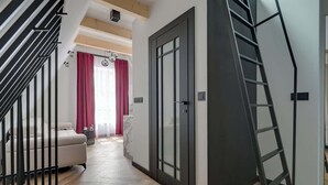 Een modern interieur met een trap, een bank en een deur met ruit.