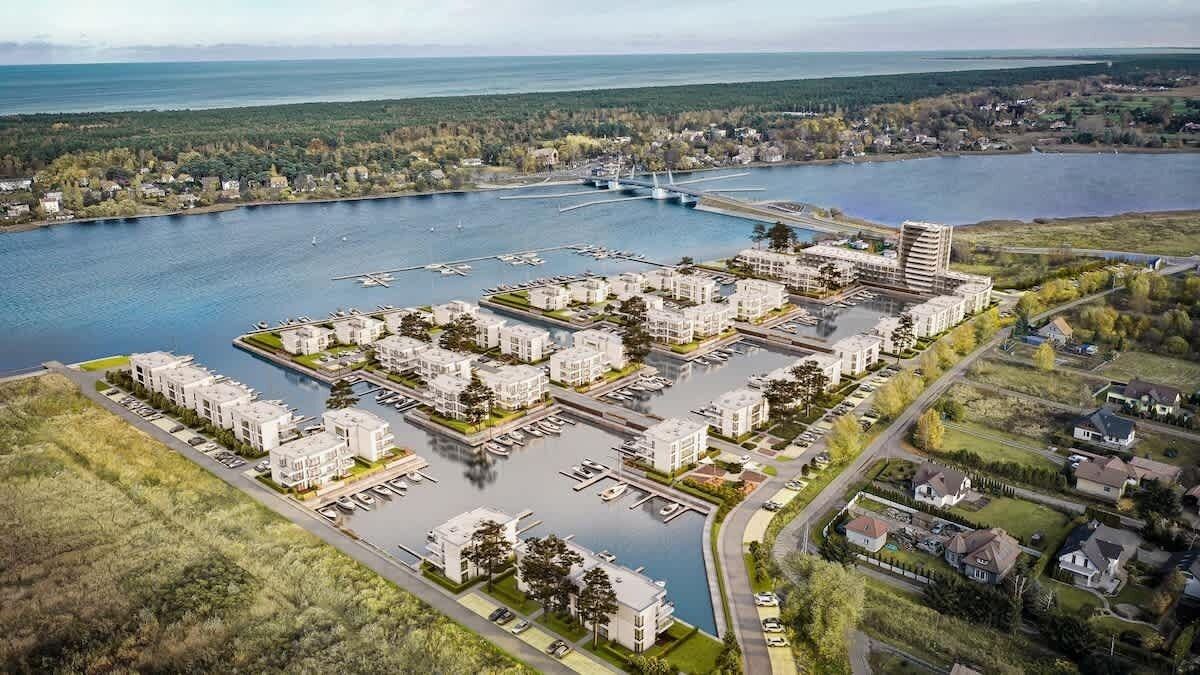 Vue aérienne d’un quartier résidentiel avec des bâtiments modernes, une marina et un pont.