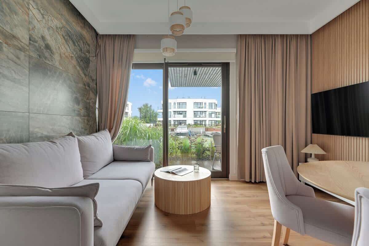 Une chambre d’hôtel moderne avec un canapé, une table basse ronde et un coin repas.