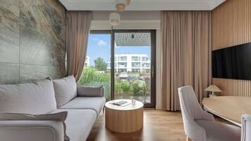 Une chambre d’hôtel moderne avec un canapé, une table basse ronde et un coin repas.
