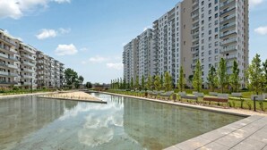 Een wooncomplex met hoge gebouwen, een centraal gelegen zwembad en een verzorgd park.