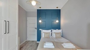 Een hotelkamer met een bed, een witte kast en een deur.