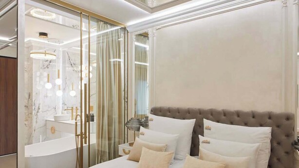 A luxurious bedroom with a large bed, a vanity with a mirror, and a modern chandelier. - Jacuzzi Mirror Suite Nadmotławie Estate 111 (Gdańsk)