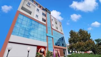 A multi-story hotel with a prominent 'HOTEL' sign, large windows, and a well-maintained entrance area.