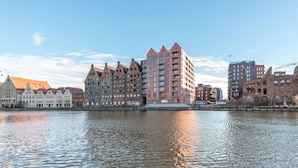 A waterfront cityscape with historic buildings and a modern high-rise. - Nº 53 | Pool, SPA & Gym (Gdańsk)