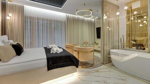 A modern bedroom with a large bed, a sitting area, a bathtub, and a large mirror. - Nadmotławie124 | Romantic Stay | Riverside & Sauna (Gdańsk)