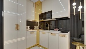 A modern kitchen with white cabinetry, a black microwave, and gold accents. - Nadmotławie124 | Romantic Stay | Riverside & Sauna (Gdańsk)