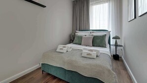 A neatly arranged bedroom with a bed, pillows, a bedside table, and a lamp. - Scala 37 with Balcony | City Center | Parking (Gdańsk)
