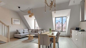 Een modern loft appartement met een eetgedeelte, keuken en een groot raam met uitzicht op de stad.