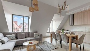 Een modern loft appartement met een eetgedeelte, keuken en een groot raam met uitzicht op de stad.