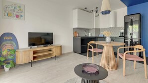 Moderni keittiö, jossa on valkoiset kaapit, musta työtaso ja riippuvalaisin.
