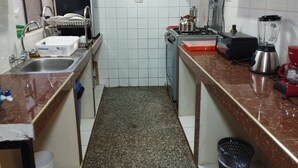 A compact kitchen with a sink, stove, toaster, blender, and a small refrigerator. - Huaytusive (Puno)